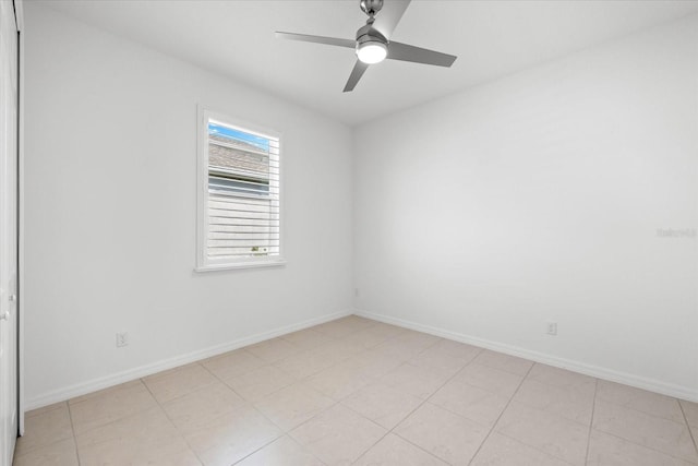 spare room featuring a ceiling fan and baseboards