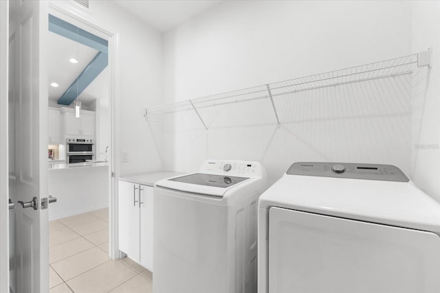 laundry room with recessed lighting, cabinet space, washing machine and clothes dryer, and light tile patterned floors