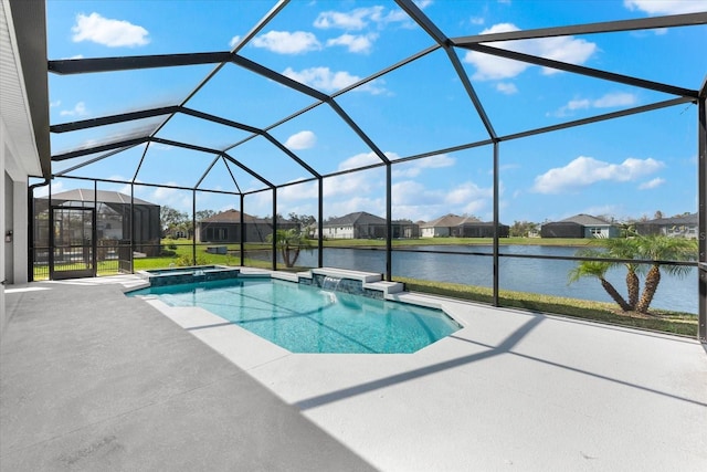 view of pool featuring a patio, a pool with connected hot tub, a water view, glass enclosure, and a residential view