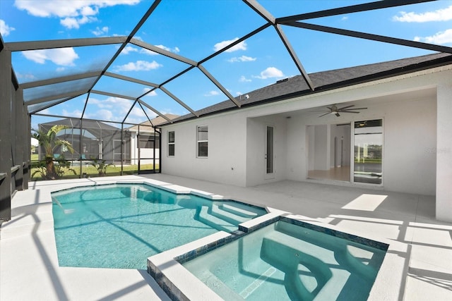 view of pool with glass enclosure, a pool with connected hot tub, and a patio