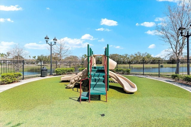 community play area with a water view and fence