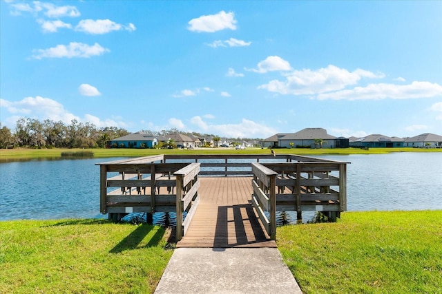 dock area featuring a water view, a residential view, and a lawn