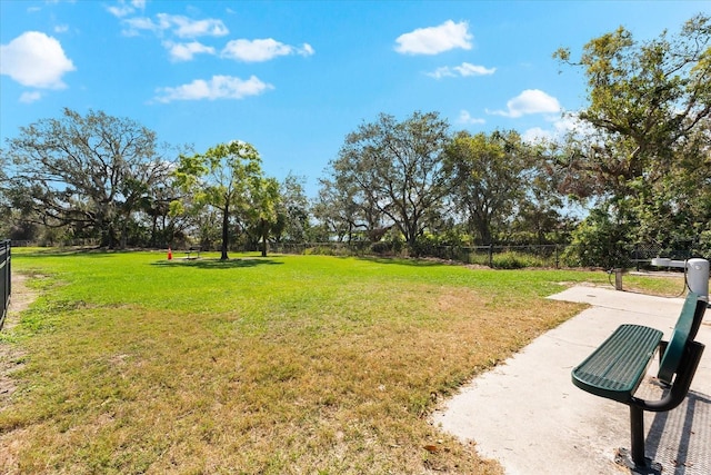 view of property's community with fence and a yard