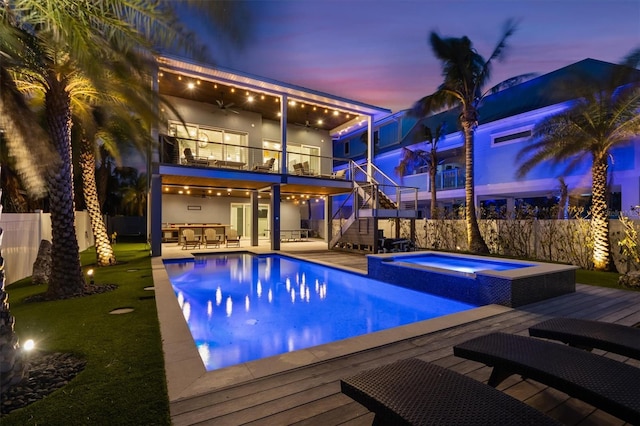 view of swimming pool featuring stairs, outdoor dining area, a fenced backyard, and a pool with connected hot tub