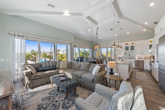 living area featuring vaulted ceiling with beams, visible vents, dark wood finished floors, and recessed lighting