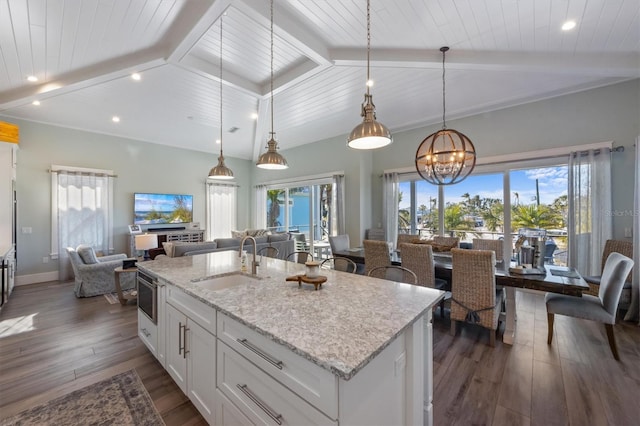 kitchen featuring dark wood-style flooring, beam ceiling, open floor plan, white cabinets, and a sink