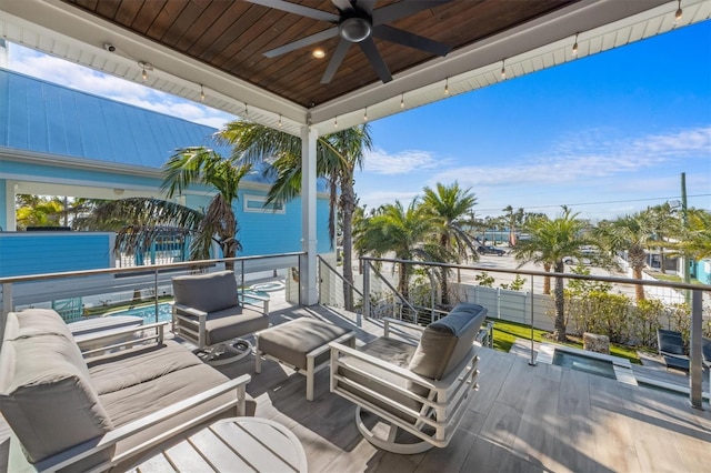 wooden deck featuring an outdoor living space and a ceiling fan