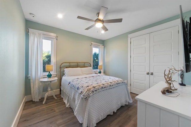 bedroom with ceiling fan, a closet, dark wood finished floors, and baseboards