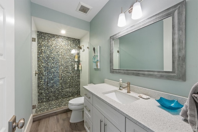 full bathroom with toilet, wood finished floors, visible vents, and a shower stall