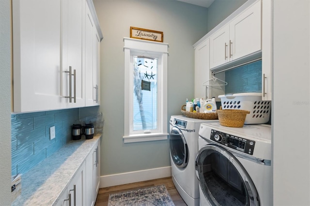 laundry area with cabinet space, baseboards, light wood finished floors, and washing machine and clothes dryer