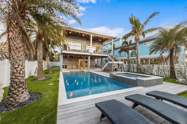 view of swimming pool with a yard, stairway, ceiling fan, a deck, and a fenced backyard