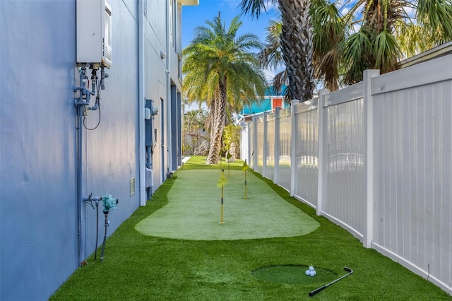 view of yard with water heater and fence