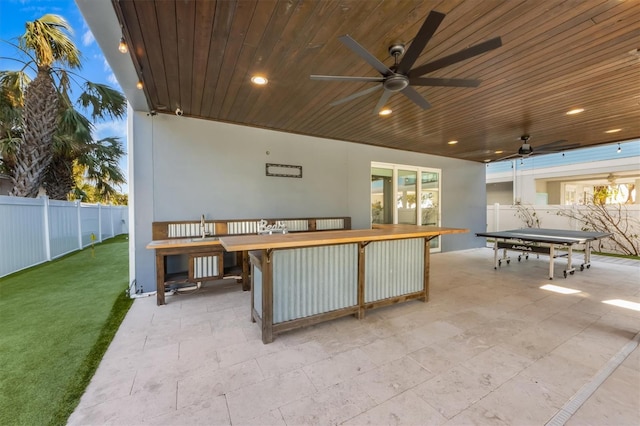 view of patio with outdoor dining area, fence, and a ceiling fan