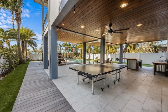 view of patio featuring stairs, a fenced backyard, and a ceiling fan