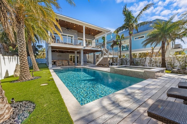 view of pool with a lawn, a ceiling fan, a fenced backyard, stairs, and a wooden deck