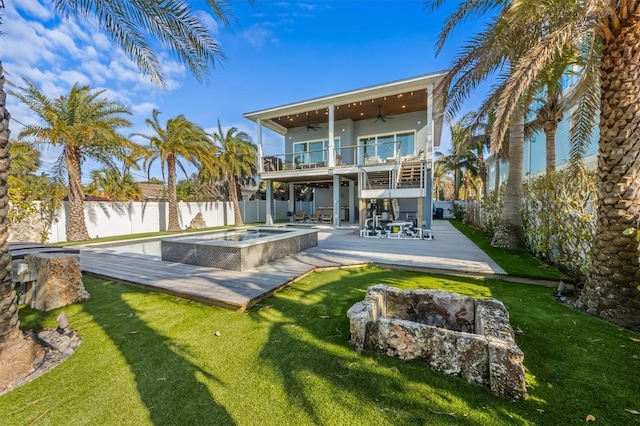 back of house with a deck, a fenced backyard, an in ground hot tub, a ceiling fan, and a yard