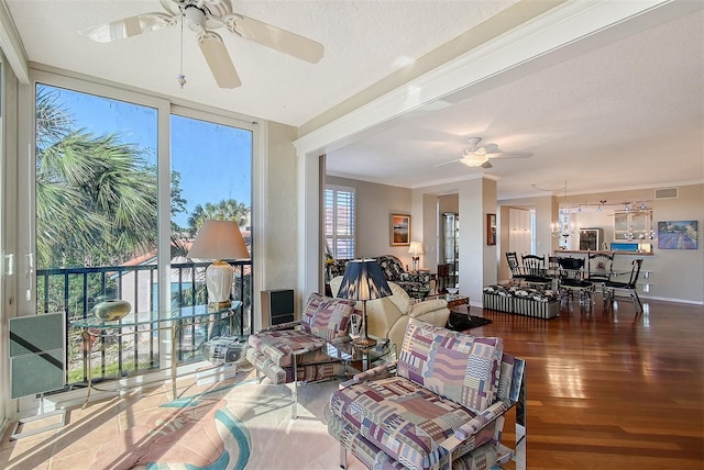 living area featuring crown molding, ceiling fan, floor to ceiling windows, wood finished floors, and a textured ceiling