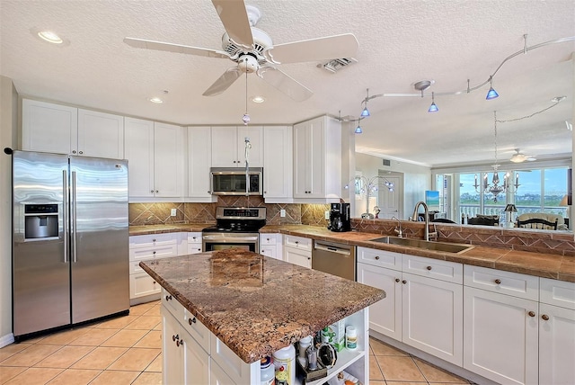 kitchen with visible vents, a sink, tasteful backsplash, stainless steel appliances, and light tile patterned floors