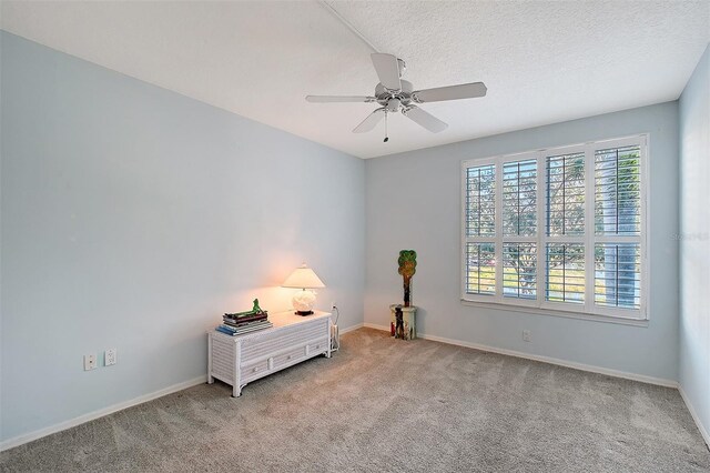 bedroom featuring ceiling fan, light colored carpet, baseboards, and a textured ceiling