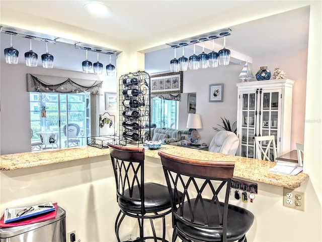2057 Sunset Dr Unit G1, Bradenton, FL 34207 - kitchen featuring pendant lighting, a breakfast bar, light stone counters, and open floor plan