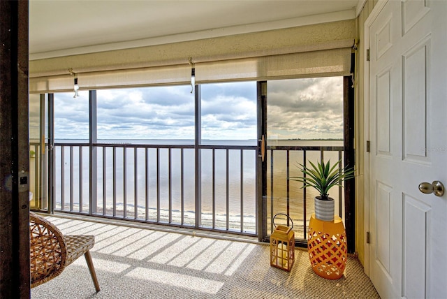 sunroom / solarium featuring a water view