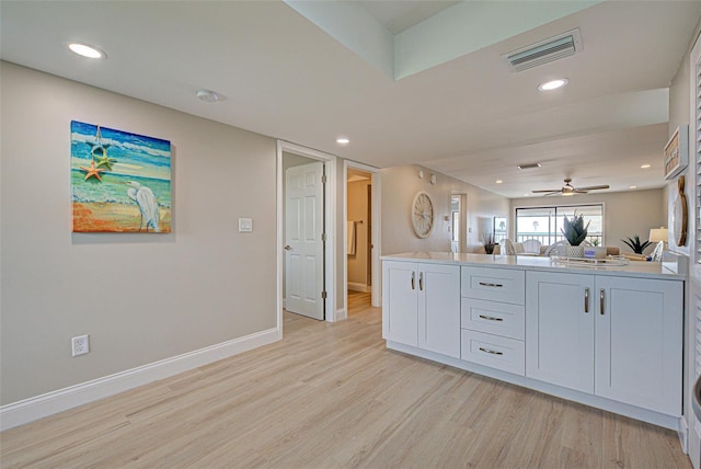 interior space featuring visible vents, white cabinets, light wood-style flooring, open floor plan, and light countertops