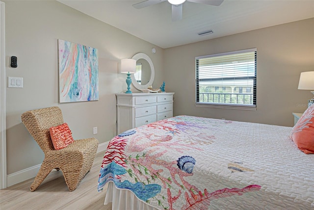 bedroom featuring a ceiling fan, light wood-type flooring, visible vents, and baseboards