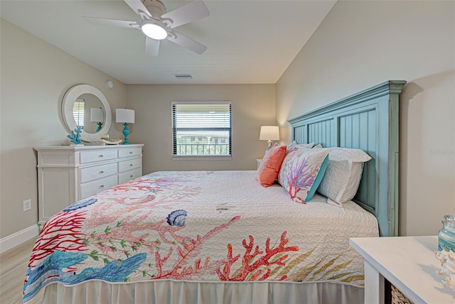 bedroom featuring light wood-style floors, visible vents, ceiling fan, and baseboards