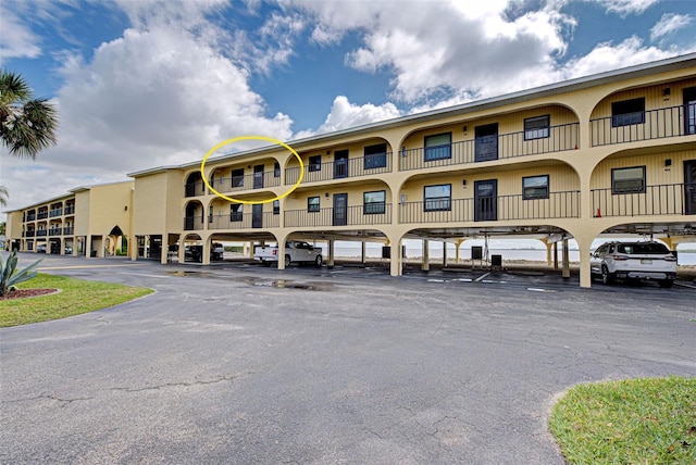 view of property with covered and uncovered parking