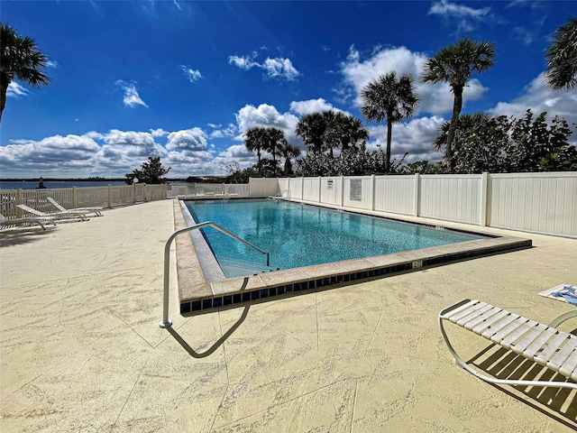 pool with a patio area and fence