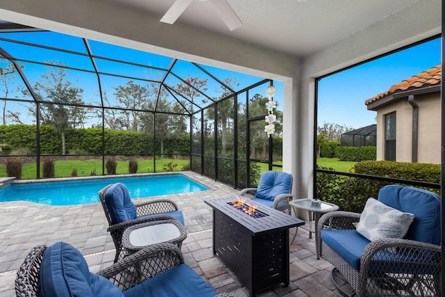 outdoor pool with a patio area, glass enclosure, a ceiling fan, and an outdoor living space with a fire pit