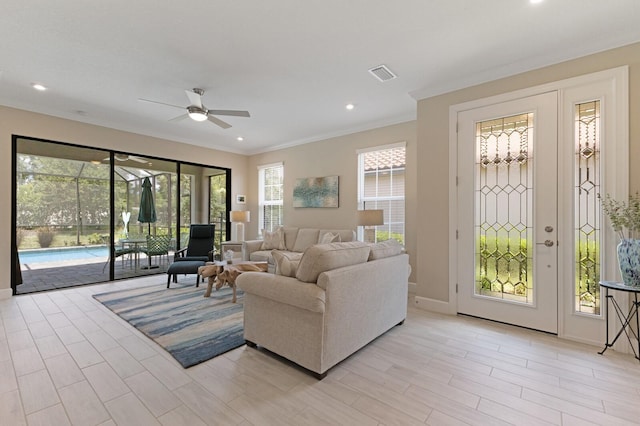 living area featuring baseboards, ornamental molding, visible vents, and recessed lighting