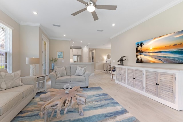 living area with recessed lighting, visible vents, light wood-style flooring, ornamental molding, and baseboards