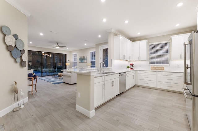 kitchen featuring a peninsula, decorative backsplash, stainless steel appliances, and a sink