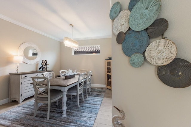 dining space with light wood-type flooring, baseboards, and ornamental molding