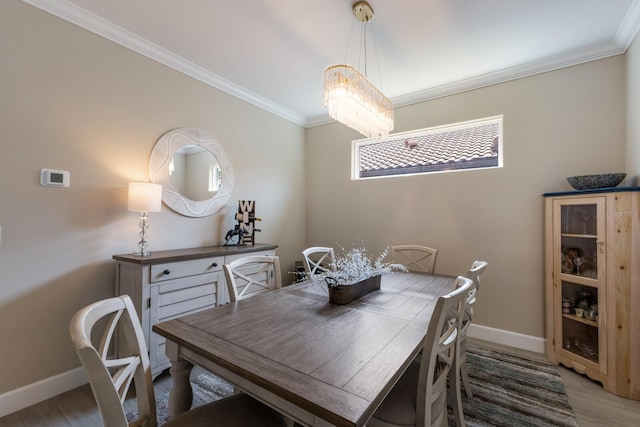 dining space featuring light wood-style floors, baseboards, and ornamental molding