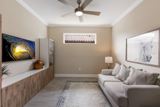 living area featuring ornamental molding, baseboards, ceiling fan, and light wood finished floors