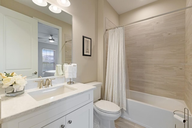 bathroom featuring toilet, wood finished floors, vanity, a ceiling fan, and shower / bath combination with curtain