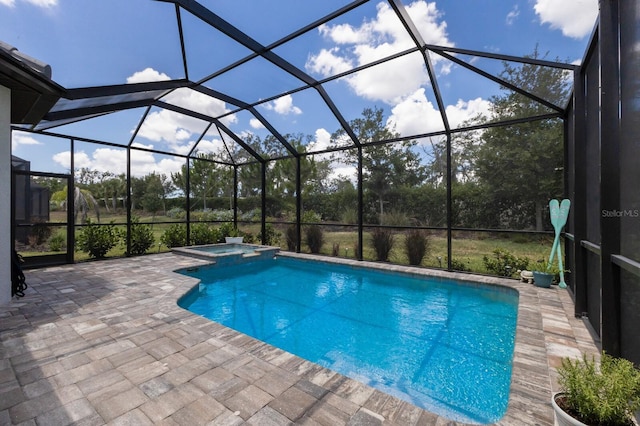 view of swimming pool with a pool with connected hot tub, a patio, and a lanai