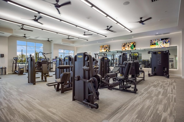 exercise room featuring carpet floors, ceiling fan, and baseboards