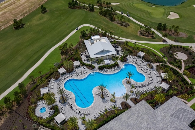 community pool featuring view of golf course and a patio