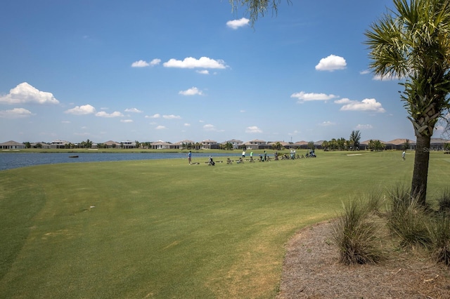 view of home's community with a water view and a yard