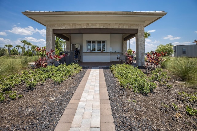 entrance to property featuring covered porch and stucco siding