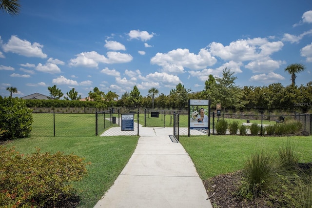 view of community with a gate, a yard, and fence