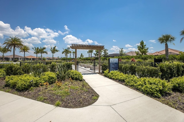 view of home's community featuring a gate, fence, and a pergola