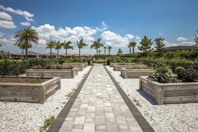 view of community with a garden and fence