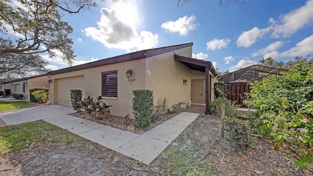 view of front of home with a garage, driveway, and stucco siding