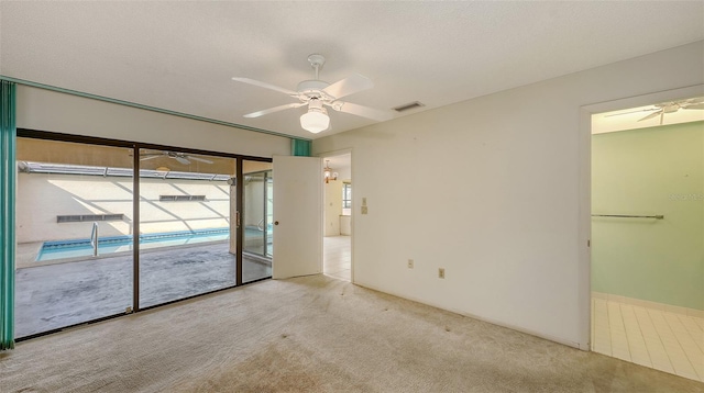 unfurnished room with visible vents, ceiling fan, light carpet, and a textured ceiling