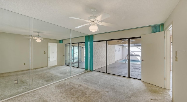 empty room featuring carpet flooring, ceiling fan, and a textured ceiling