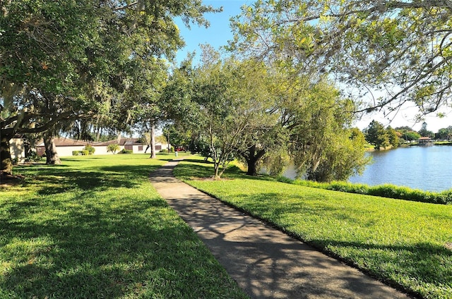 view of home's community with a water view and a yard
